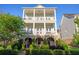 Elegant three-story home with double balconies, brick accents, and a beautifully landscaped front yard at 7120 Lullwater Rd, Cumming, GA 30040