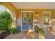 Inviting front porch with brick columns, a welcome mat, and decorative lanterns at 7120 Lullwater Rd, Cumming, GA 30040
