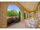 Inviting brick front porch with arched openings and comfortable wicker seating, perfect for relaxing outdoors at 7120 Lullwater Rd, Cumming, GA 30040