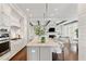 Open kitchen with a spacious island, white cabinets, and hardwood floors connects seamlessly to the living area at 7120 Lullwater Rd, Cumming, GA 30040