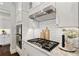 Gourmet kitchen featuring stainless steel appliances, white cabinets, and elegant finishes for a luxurious cooking experience at 7120 Lullwater Rd, Cumming, GA 30040
