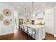 Stylish kitchen features a spacious island with seating, hardwood floors, and white cabinets, creating a modern, inviting space at 7120 Lullwater Rd, Cumming, GA 30040