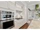 Elegant kitchen with stainless steel appliances, white cabinets, and granite countertops for a sophisticated cooking space at 7120 Lullwater Rd, Cumming, GA 30040