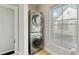 Efficient laundry area featuring a stacked washer and dryer set next to a window at 7120 Lullwater Rd, Cumming, GA 30040