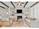 Bright living room with a stone fireplace, decorative ceiling beams, and neutral-toned furniture, creating a cozy atmosphere at 7120 Lullwater Rd, Cumming, GA 30040
