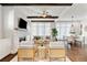 Open-concept living space with stone fireplace, dark wood beams, and dining area at 7120 Lullwater Rd, Cumming, GA 30040