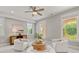 Bright sitting area with white chairs, neutral walls, and natural light from the large windows at 7120 Lullwater Rd, Cumming, GA 30040