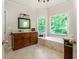 Bathroom with dark wood cabinets, granite countertops, and a soaking tub by a window at 12350 Stevens Creek Dr, Alpharetta, GA 30005