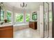 Bright bathroom featuring dual sinks, a soaking tub, and a glass enclosed shower at 12350 Stevens Creek Dr, Alpharetta, GA 30005