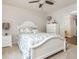 Bedroom with neutral walls, carpet, a bed with floral bedding and pillows, two bedside tables with lamps, and an open doorway at 12350 Stevens Creek Dr, Alpharetta, GA 30005