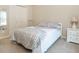 Bright bedroom features neutral walls, carpet, and a bed with patterned bedding and a white bedside table with lamp at 12350 Stevens Creek Dr, Alpharetta, GA 30005
