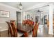 Open-concept dining area with wood table, chandelier, and view of living space with staircase at 12350 Stevens Creek Dr, Alpharetta, GA 30005