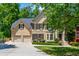 Beautiful two-story home boasts manicured landscaping, a two-car garage, and mature trees at 12350 Stevens Creek Dr, Alpharetta, GA 30005