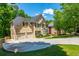 Beautiful two-story house with a three-car garage, green lawn, and mature trees; a charming home that welcomes you at 12350 Stevens Creek Dr, Alpharetta, GA 30005