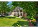 Traditional two-story home with lush front lawn, mature trees, and a two-car garage at 12350 Stevens Creek Dr, Alpharetta, GA 30005