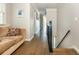 Hallway featuring hardwood floors, a staircase with dark railing, and a comfortable sofa at 12350 Stevens Creek Dr, Alpharetta, GA 30005