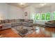 Spacious living room featuring hardwood floors, large sectional sofa, bay window, and comfortable armchair at 12350 Stevens Creek Dr, Alpharetta, GA 30005
