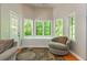 Bright, airy sunroom featuring hardwood floors, swivel chair, bay windows, and cozy nook at 12350 Stevens Creek Dr, Alpharetta, GA 30005