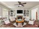 Bright living room with a stone fireplace, built-in shelving, and comfortable seating at 12350 Stevens Creek Dr, Alpharetta, GA 30005