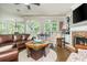 Bright living room features a stone fireplace, built-in shelving, and large windows at 12350 Stevens Creek Dr, Alpharetta, GA 30005
