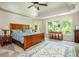 Bright main bedroom with a large wooden bed, carpet floors, and natural light at 12350 Stevens Creek Dr, Alpharetta, GA 30005