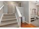 Staircase with neutral carpet leading to wood floors and a bathroom with modern tile and decor at 12350 Stevens Creek Dr, Alpharetta, GA 30005