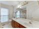 Bright bathroom featuring a double sink vanity and large mirror reflecting the shower and window at 2682 Freemans Walk Path, Dacula, GA 30019