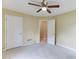 Bedroom with neutral carpet, white doors, and a ceiling fan; an open doorway leads to another room at 2682 Freemans Walk Path, Dacula, GA 30019