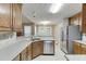 Well-appointed kitchen features stainless steel appliances, warm wood cabinetry, and tile countertops for a modern touch at 2682 Freemans Walk Path, Dacula, GA 30019