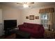 Cozy living room with a red couch, two windows, and a ceiling fan at 3024 Orchard Ridge Cir, Duluth, GA 30096