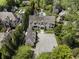 Stunning aerial view of an estate home with lush landscaping and a large driveway, offering privacy and curb appeal at 3888 Peachtree Dunwoody Rd, Atlanta, GA 30342