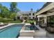 Gorgeous backyard featuring a pool, spa, covered patio, and beautifully landscaped grounds at 3888 Peachtree Dunwoody Rd, Atlanta, GA 30342