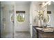 Bright bathroom featuring a glass enclosed shower, rustic vanity, and unique oval window at 3888 Peachtree Dunwoody Rd, Atlanta, GA 30342
