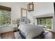 Bedroom featuring hardwood floors, a large window, and decorative headboard at 3888 Peachtree Dunwoody Rd, Atlanta, GA 30342