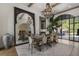 Elegant dining room with large mirror, wooden chandelier, seating for eight, and access to outdoor patio at 3888 Peachtree Dunwoody Rd, Atlanta, GA 30342