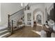 Grand foyer with staircase, arched doorways, and hardwood floors at 3888 Peachtree Dunwoody Rd, Atlanta, GA 30342