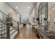 Long hallway featuring hardwood floors, an exposed brick wall, and decorative wrought iron staircase at 3888 Peachtree Dunwoody Rd, Atlanta, GA 30342