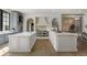 Spacious kitchen featuring double islands, stainless steel appliances, ample counter space, and wood flooring at 3888 Peachtree Dunwoody Rd, Atlanta, GA 30342