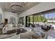 Bright open concept living room flowing to outdoor patio with pool views, modern lighting, and comfortable seating at 3888 Peachtree Dunwoody Rd, Atlanta, GA 30342