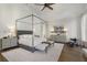 Spacious main bedroom with canopy bed, accent chair, and hardwood floors at 3888 Peachtree Dunwoody Rd, Atlanta, GA 30342