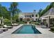 Backyard features a pool and spa with lounge seating and mature trees at 3888 Peachtree Dunwoody Rd, Atlanta, GA 30342