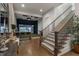 Spacious room features a golf simulator, adjacent bar, and carpeted staircase with wooden handrail at 3888 Peachtree Dunwoody Rd, Atlanta, GA 30342