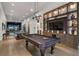 Large recreation room with a pool table, tv, built-ins, and an adjacent bar and golf simulator at 3888 Peachtree Dunwoody Rd, Atlanta, GA 30342