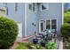 Back patio featuring an outdoor dining set, blue accents, and lush landscaping at 655 Grove Manor Ct, Suwanee, GA 30024