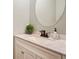 Elegant powder room with marble countertop, vanity, round mirror, and sleek faucet at 655 Grove Manor Ct, Suwanee, GA 30024