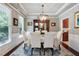 Elegant dining room with a tray ceiling, wainscoting, and a stylish chandelier at 655 Grove Manor Ct, Suwanee, GA 30024