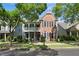 Attractive two-story brick home with a cozy double porch, framed by lush landscaping and mature trees at 655 Grove Manor Ct, Suwanee, GA 30024