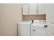 Convenient laundry room with white washer, dryer, and storage cabinets at 655 Grove Manor Ct, Suwanee, GA 30024