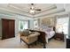 Relaxing main bedroom with tray ceiling, fan, sitting area, and natural light at 655 Grove Manor Ct, Suwanee, GA 30024