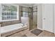Bathroom featuring a tub, a glass door shower and white cabinets at 1500 Highland Farm Dr, Suwanee, GA 30024